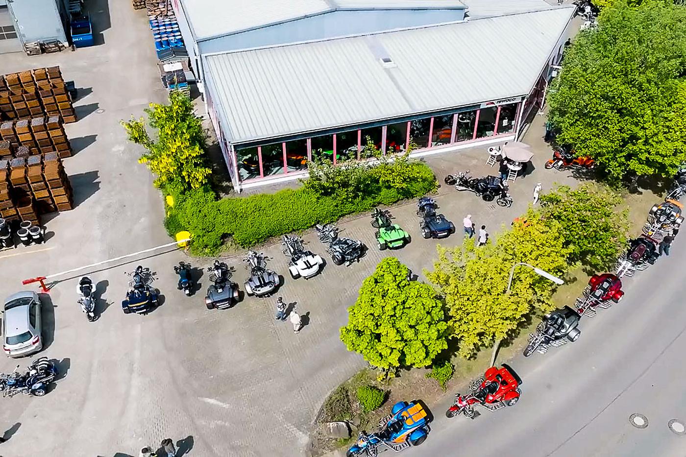Luftbild der rewaco Hausmesse in Lindlar: Ausstellungshalle, davor viele Trikes und Besucher auf dem Hof